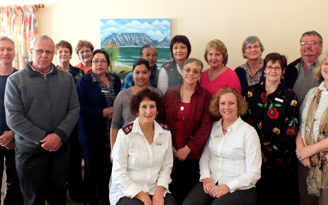 â€˜n Deel van die Hospice seminaar-gangers in Herberg-aan-See se sitkamer, met voor die seminaar-aanbieders, Suster Gerna van der Riet en Fransil Kotze